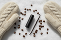 black lipbalm tube with white snow background coffee beans vanilla stick cozy mittens